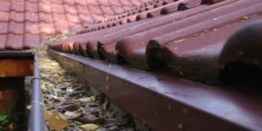 Schmutzige Dachrinne mit Laub
